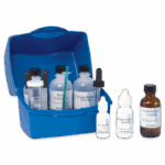 A blue plastic box labeled Tolcide PS Biocides Test Kit - 4-8776-01 holds various bottles and droppers with scientific solutions, such as Borate Buffer, PS Solution, Iodine Solution, and Starch Indicator arranged neatly in front.